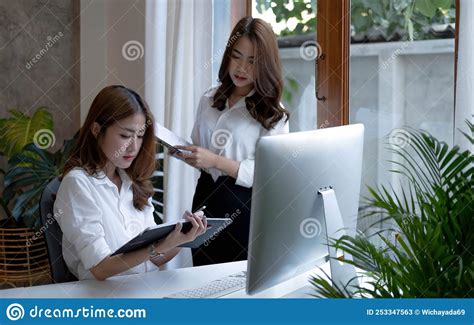 Two Young Beautiful Asian Business Woman In The Conversation