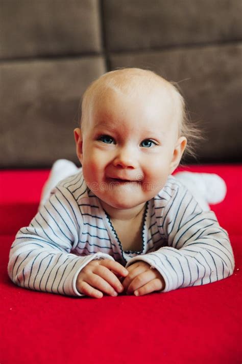 Curious Baby Girl Lying On Bed Smiling Front View Stock Image Image
