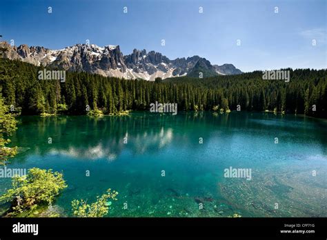 Lake Karersee In The Sunlight In Front Of Dolomites Nature Reserve