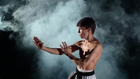 Karate Man With A Naked Torso And A Black Belt Doing Various Exercises Hands Smoke Close Up