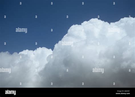 High Bank Of Billowing White Cumulus Or Cumulonimbus Cloud With A Grey