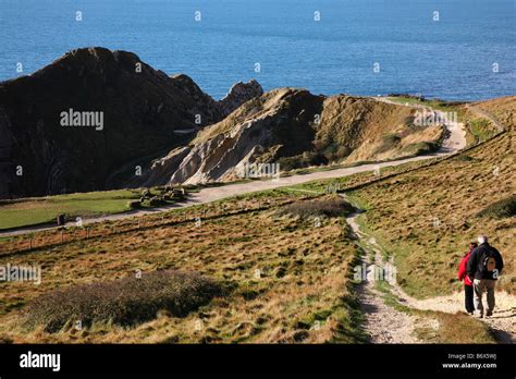 Walkers On The Coastal Footpath Above Durdle Door On Dorsets Jurassic