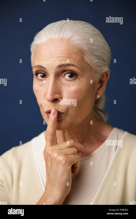 Close Up Portrait Of Beautiful Old Woman Showing Silence Gesture Over