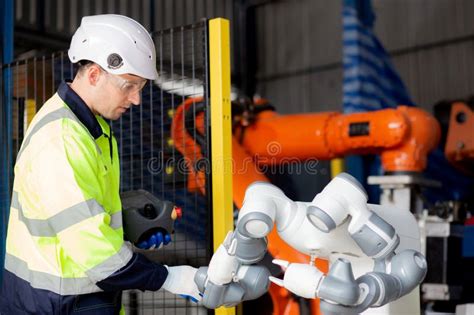 Young Engineer Man Checking And Maintenance Machine Robot Arms