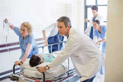 Doctors And Nurses Rushing Patient On Stretcher Down Hospital Corridor Stock Photo Dissolve