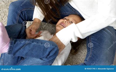Mother Tickling Young Daughter Both Laughing And Having A Good Time