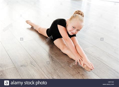 Smiling Beautiful Little Girl Ballerina Doing Twine In Ballet Studio
