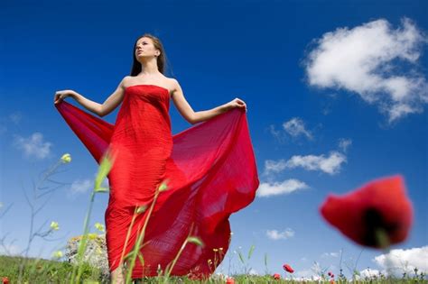 Premium Photo Young Beautiful Woman In Red Dress Standing On The Field