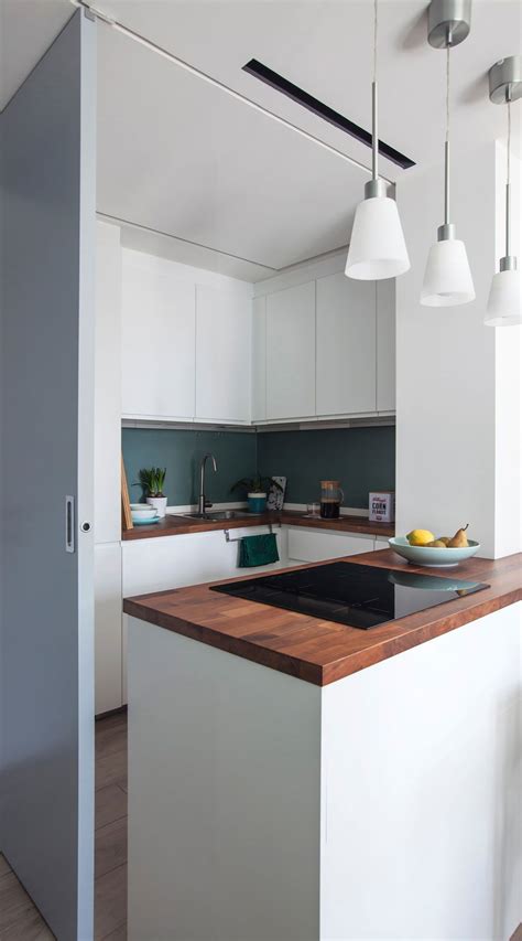 A Modern Kitchen With White Cabinets And Wood Counter Tops Is Seen From