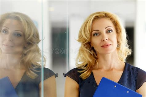 Mature Blonde Smiling Businesswoman Stand Near Glass Door Stock Image