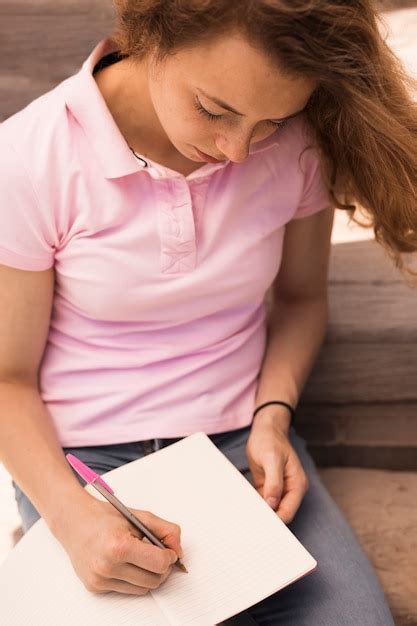 Free Photo Cute Teenager Writing In Copybook