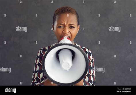 Portrait Of A Serious Angry Dark Skinned Woman Shouting Loudly Into A