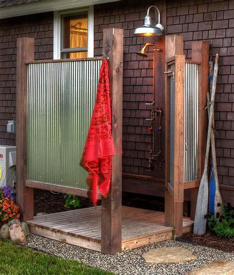An Outdoor Shower In Front Of A House With A Red Towel Hanging From It