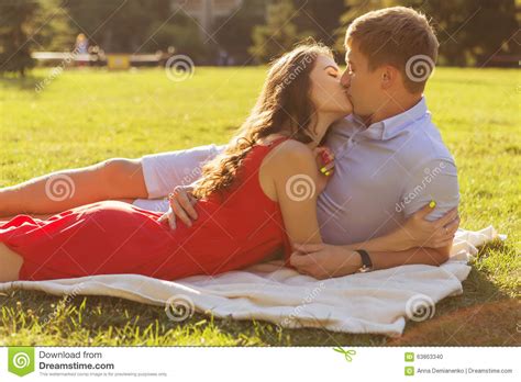 Beautiful Brunette Couple In Love Kissing On A Date In The Park Stock