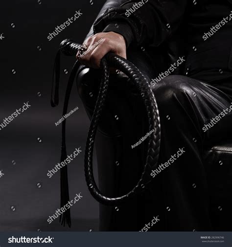 Стоковая фотография Male Hand Holding Black Leather Whip изменить