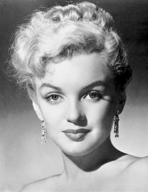 An Old Black And White Photo Of A Woman With Large Earrings On Her Head