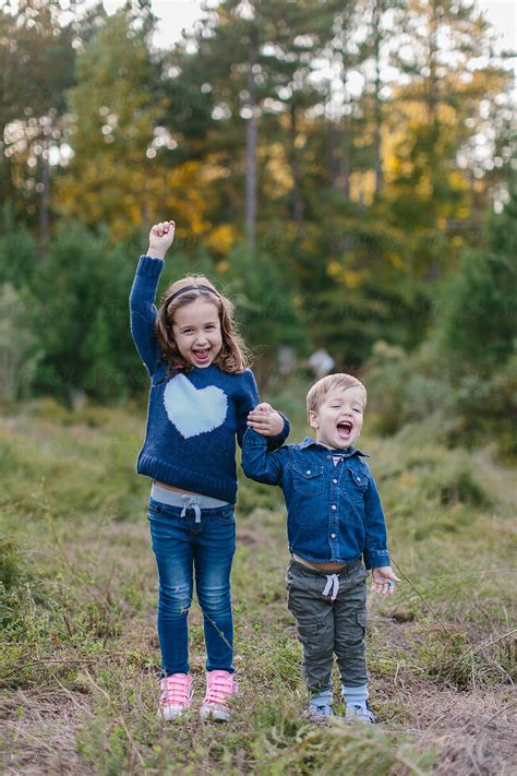 Cute Brother And Sister Holding Hands And Laughing By Stocksy