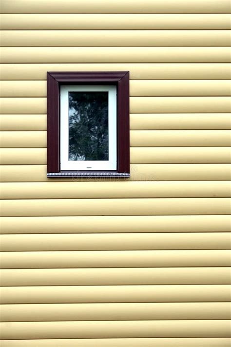 Building Wall With Plastic Window Covered With Beige Siding Panels