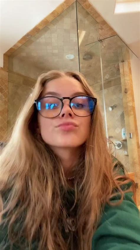 A Woman Wearing Glasses Taking A Selfie In The Bathroom With Her Hair