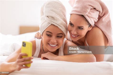 Mom And Daughter Having Wellness Time At Home Wearing Towels On Their Heads Taking Selfies Stock