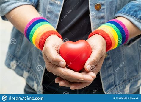 Asian Lady Wearing Rainbow Wristbands And Hold Red Heart Symbol Of