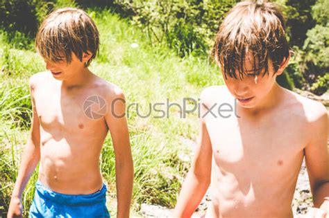 Young Boys Have Fun At The Small River Outdoor Summer Stock Photo