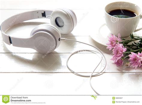 Headphones And Coffee Cup On Wooden Desk Table With Pink Flower Music