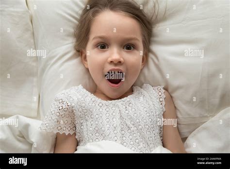 Top View Of Little Girl Lying In Bed Feel Surprised Stock Photo Alamy