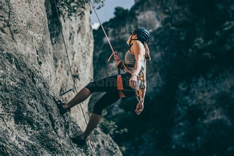 Female Hanging From A Wall With A Rope During Rock Climbing Journey