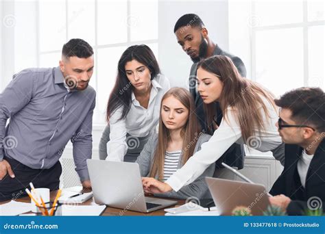 Business People Gathered Around Laptop Discussing Ideas Stock Photo