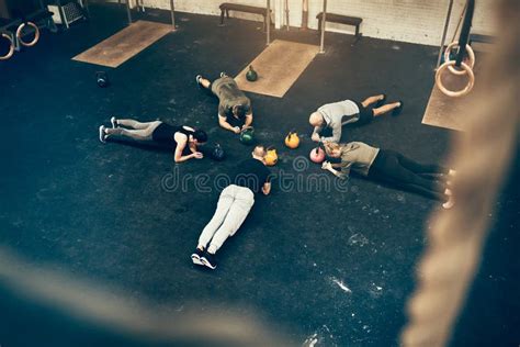 Group Of Fit People Planking Together On A Gym Floor Stock Photo