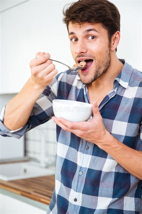 Happy Man Eating Cereal For Breakfast In Kitchen Stock Photo Image Of