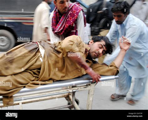 People shift an injured victim, who was injured in bomb explosion at Stock Photo: 40730523 - Alamy