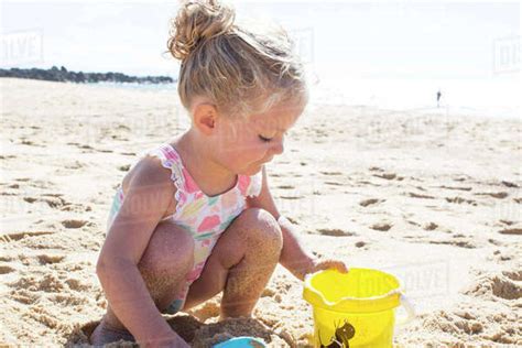Little Girl Playing In Sand On Beach Stock Photo Dissolve