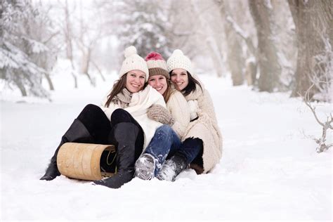 Three Women Sitting On Snow Covered Ground During Day · Free Stock Photo