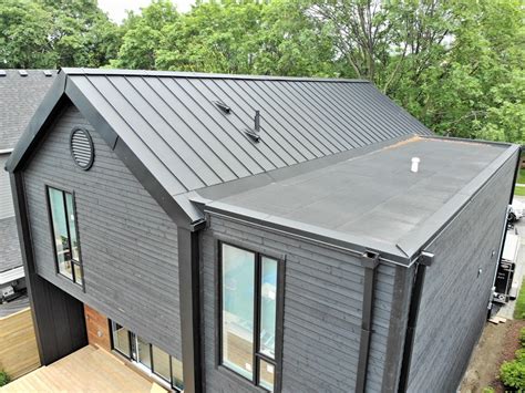 Standing seam metal roof and façade and flat roof with parapets gutters and fascia from Roof