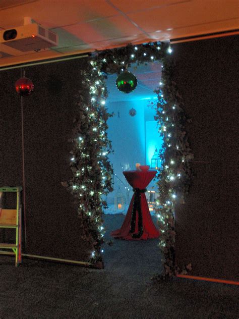 archway decorated with ivy and entwined with fairy lights provides a festive entrance through to
