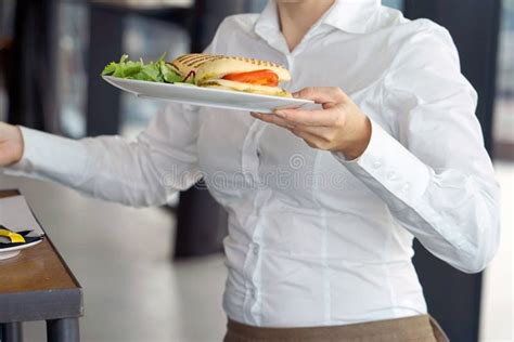 The Waitress Is Carrying A Plate Of Food To The Client Stock Photo