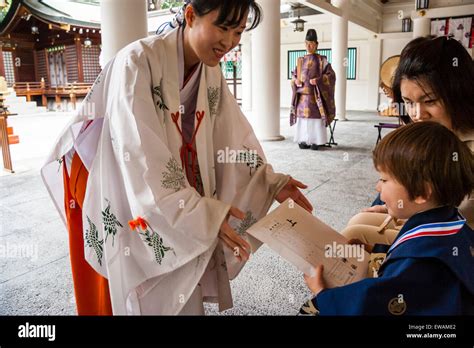 Miko A Japanese Shrine Maiden Handing Wrapped Scroll To Child Boy 5