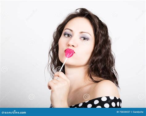 Portrait Of Happy Beautiful Young Woman Licking Sweet Candy And