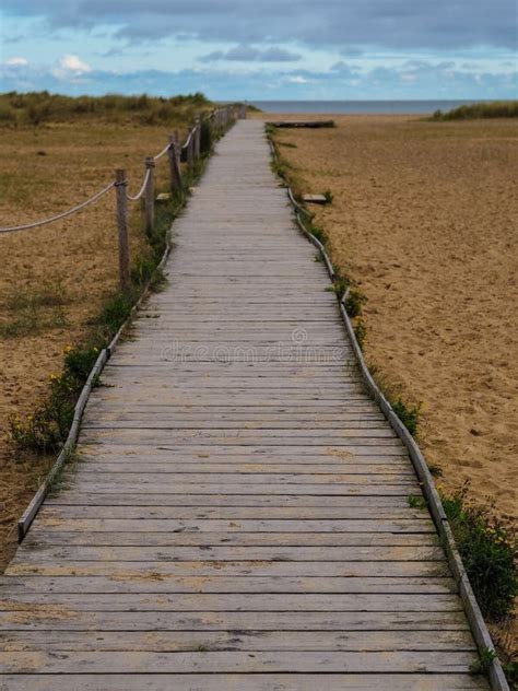 Wooden Walkway To Beach And Horizon With Beach Huts And Dunes Stock