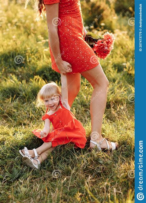 Portrait Of A Mother Holds Throws Up And Spins The Daughter On Hands On Nature On Summer Day