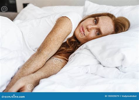 Image Of Ginger Pleased Woman Looking At Camera While Lying In Bed