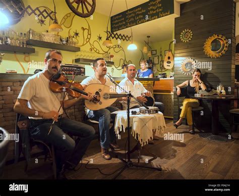 People Sitting In Restaurant While Three Men Playing Music In Izmir
