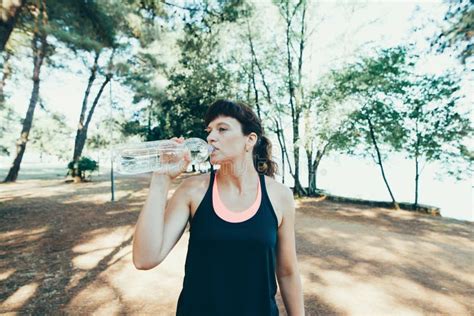 Woman Drinking Water After Exercise In Park Stock Photo Image Of