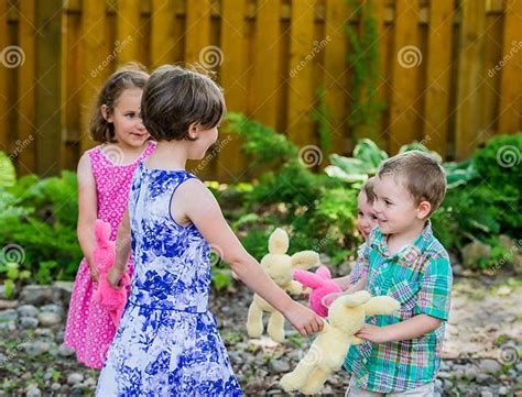 Two Girls And Two Boys Playing Ring Around The Rosie Stock Image