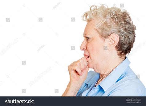 closeup side view profile portrait of senior mature woman with finger in mouth sucking thumb