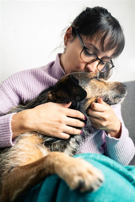 Latin American Woman Wearing Glasses Kissing Her Dog With Love Stock