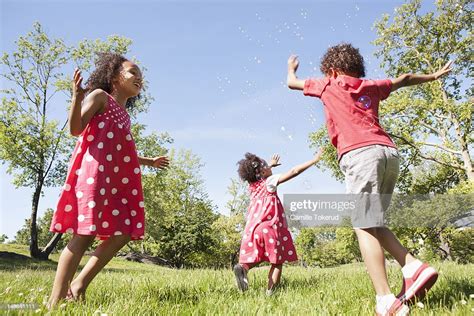 Three Little Kids Playing With Bubbles In Park High Res Stock Photo