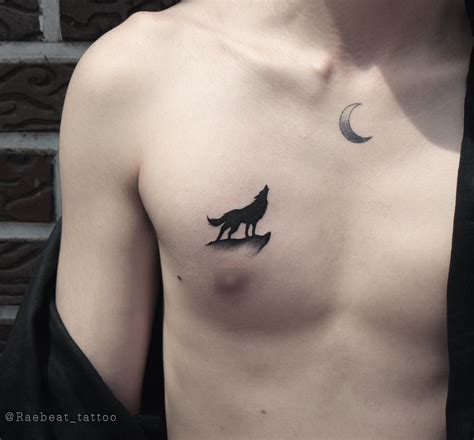 A Small Black Howling Wolf Tattoo On The Right Side Of The Chest